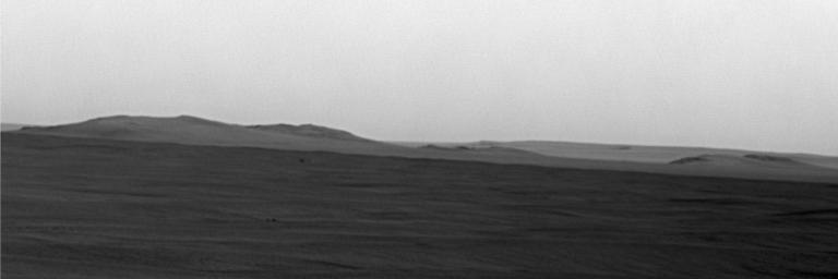This image from NASA's rover Opportunity shows mostly a portion of Endeavour's western rim (left); a paler-looking terrain on the horizon beyond Endeavour (right) is part of a thick deposit of material ejected by the impact that excavated Iazu Crater.