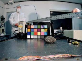 Ken Edgett, deputy principal investigator for NASA's Mars Descent Imager, holds a ruler used as a depth-of-field test target. The instrument took this image inside the Malin Space Science Systems clean room in San Diego, CA, during calibration testing.
