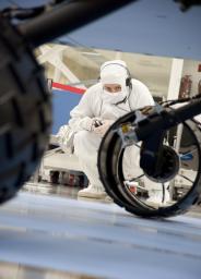 A test operator in clean-room garb observes rolling of the wheels during the first drive test of NASA's Curiosity rover, on July 23, 2010. Technicians and engineers conducted the drive test at the Jet Propulsion Laboratory in Pasadena, Calif.