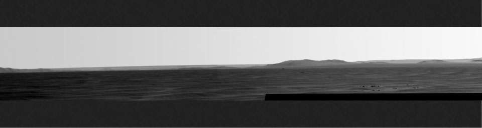 Rising highest above the horizon in the right half of the image, captured by NASA's Mars Exporation Rover, is a portion of the western rim of Endeavour Crater including a ridge informally named 'Cape Tribulation.'