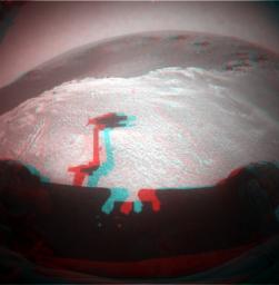 This image from NASA's Mars Rover Opportunity is from the edge of a football-field-size crater informally named 'Santa Maria.' The rover's upraised robotic arm, itself out of view, casts a dragon-shaped shadow in the foreground. 3D glasses are necessary.