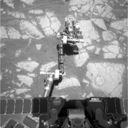 NASA's Mars Exploration Rover Opportunity used its rock abrasion tool on a rock informally named 'Gagarin,' leaving a circular mark. At the end of the rover's arm, the tool turret is positioned with the rock abrasion tool pointing upward.