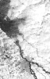 NASA's Terra spacecraft shows the annual spring thaw in the upper Midwest is underway. Snow-covered ground contrasts with the dark tones of water under broken cloud cover. Along the Red River in North Dakota, floodwaters are moving northward into Canada.