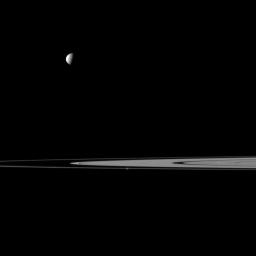 Saturn's rings lie between a pair of moons in this view from NASA's Cassini spacecraft that features Mimas and Prometheus. Mimas is the more noticeable of the two moons at top left, Prometheus is near the center of image and closest to Cassini.