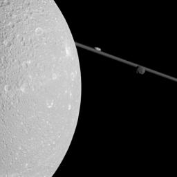 Flying past Saturn's moon Dione, NASA's Cassini captured this view which includes two smaller moons, Epimetheus and Prometheus, near the planet's rings.