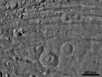 This image from NASA's Dawn spacecraft shows dark material at impact craters, up to 12.5 miles-wide (20 kilometer-wide) and sets of worm-like tracks in the north-south direction.