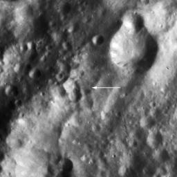 The image shows Claudia (arrow), a tiny crater through which by definition Vesta's prime meridian runs from the asteroid's north pole to its south pole. This image is from NASA's Dawn spacecraft.