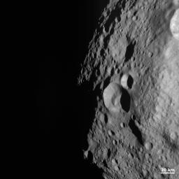 NASA's Dawn spacecraft obtained this image of a young and old crater at the night and day boundary on asteroid Vesta. The image has a resolution of about 260 meters per pixel.