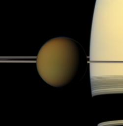 The colorful globe of Saturn's largest moon, Titan, passes in front of the planet and its rings in this true color snapshot from NASA's Cassini spacecraft.