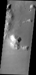 Dark streaks mark the sides of this mesa where the movement of material has exposed the darker rock beneath. This mesa (or hill) is just one of hundreds in Tartarus Colles. This image was captured by NASA's 2001 Mars Odyssey spacecraft.