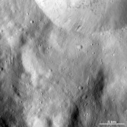 This image from NASA's Dawn spacecraft shows part of the sharp, fresh rim of a large crater on asteroid Vesta. There is some bright material slumping towards the center of this crater but this is mostly overshadowed by the dark material.