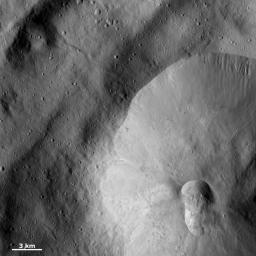 A double crater, called a crater doublet, is seen in the bottom right part of this image from NASA's Dawn spacecraft of asteroid Vesta. This crater doublet was likely formed by the simultaneous impact of two fragments of a split projectile.