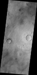 This image from NASA's 2001 Mars Odyssey spacecraft shows dark markings mar the surface of Mars' northern plains. While many may be the tracks of dust devils, some marks may be narrow fractures.