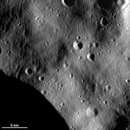 This image from NASA's Dawn spacecraft of asteroid Vesta shows chains of craters on an undulating surface probably formed of fine-grained debris, called regolith, which was ejected from large impact craters as they formed nearby.