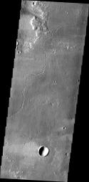 This image from NASA's 2001 Mars Odyssey spacecraft shows a channel carved by lava on Mars. This channel is located northeast of Olympus Mons.