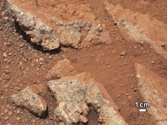 In this image from NASA's Curiosity rover, a rock outcrop called 'Link' pops out from a Martian surface that is elsewhere blanketed by reddish-brown dust.