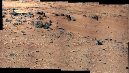 This patch of windblown sand and dust downhill from a cluster of dark rocks is the 'Rocknest' site, which has been selected as the likely location for first use of the scoop on the arm of NASA's Mars rover Curiosity.
