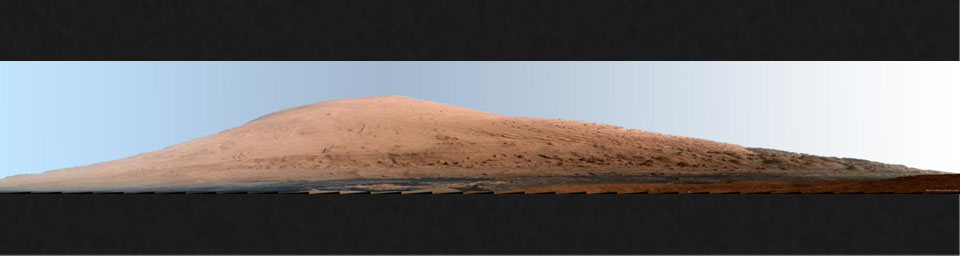 This mosaic of images from the Mast Camera (Mastcam) on NASA's Mars rover Curiosity shows Mount Sharp in a white-balanced color adjustment that makes the sky look overly blue but shows the terrain as if under Earth-like lighting.