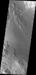 NASA's Mars Odyssey spacecraft shows a large channel on Mars. Just below the brighter material of Mt. Sharp is the start of the arced edge of material.