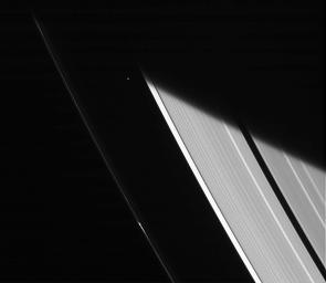 NASA's Cassini spacecraft captures a glimpse of the moon Atlas shortly after emerging from Saturn's shadow.
