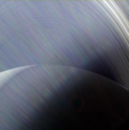 In this image, NASA's Cassini spacecraft sees Saturn and its rings through a wispy haze of Sun glare.