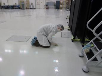 A microbiologist collects a swab sample from the floor of a spacecraft assembly clean room at NASA's Jet Propulsion Laboratory where samples such as this are taken frequently during the assembly of a spacecraft and analyzed.