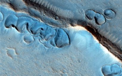 This image from NASA's Mars Reconnaissance Orbiter covers many shallow irregular pits with raised rims, concentrated along ridges and other topographic features.