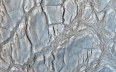 With its cracked, blistery appearance, this mound near the center of a very large, over 5-kilometer diameter mid-latitude crater poses an interesting question: how did this form? This image is from NASA's Mars Reconnaissance Orbiter.