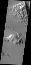 This image from NASA's 2001 Mars Odyssey spacecraft, located southwest of Olympus Mons, contains a very subtle windstreak in the bottom 1/3 of the image. Originating at a small crater, the windstreak records a wind that blew east to west.