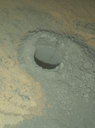 NASA's Curiosity Mars rover provided this nighttime view of a hole produced by the rover's drill and, inside the hole, a line of scars produced by the rover's rock-zapping laser.