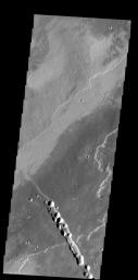 This image from NASA's 2001 Mars Odyssey spacecraft shows a small portion of the lava flows from Alba Mons. The depression and collapse features within it are part of the large system of tectonic features created by the apparent collapse of the volcano.