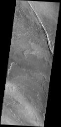 The graben in this image from NASA's 2001 Mars Odyssey spacecraft is Cyane Fossae. The lava flows are part of the extensive Tharsis volcanic flows.
