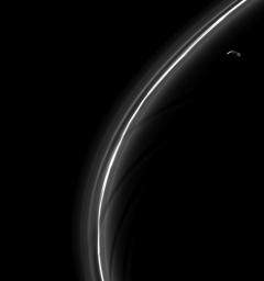 Saturn's moon Prometheus, seen here looking suspiciously blade-like, is captured by NASA's Cassini spacecraft near some of its sculpting in the F ring.