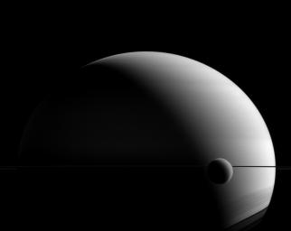 Titan and Saturn share a hazy appearance in this image from NASA's Cassini spacecraft, though Saturn is a gas giant with no solid surface to speak of, and Titan's atmosphere is a blanket surrounding an icy, solid body.
