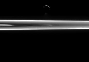 Enceladus' famous south polar water jets can be seen just above the moon's dark, southern limb in this image captured by NASA's Cassini spacecraft.