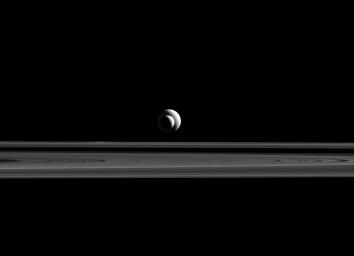 Like a cosmic bull's-eye, Enceladus and Tethys line up almost perfectly for NASA's Cassini. Since they are also at relatively similar distances from the spacecraft, their apparent sizes in this image are a good approximation of their relative sizes.