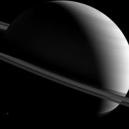 NASA's Cassini spacecraft captured this image of Saturn as it views the planet and its expansive rings from all sorts of angles. Here, a half-lit Saturn sits askew as tiny Dione looks on from lower left.