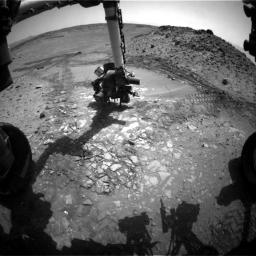This image from the front Hazcam on NASA's Curiosity Mars rover shows the rover's drill in place during a test of whether the rock beneath it, 'Bonanza King,' would be an acceptable target for drilling to collect a sample.
