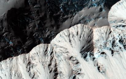 Right past the sharp, but warped rim of this ancient impact crater are deposits of winter frost, which show up as blue in enhanced color as seen by NASA's Mars Reconnaissance Orbiter.