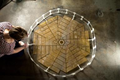 A Ph.D. student in mechanical engineering at Brigham Young University, Provo, Utah, unfolds a solar panel array that was designed using the principles of origami.
