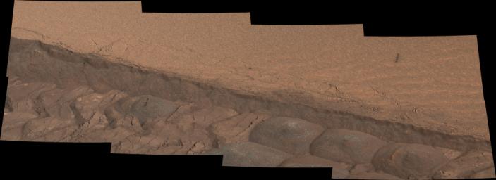 A wheel track cuts through a windblown ripple of dusty sand in this Nov. 7, 2014, image from the Mastcam on NASA's Curiosity rover. The view spans about four feet across.