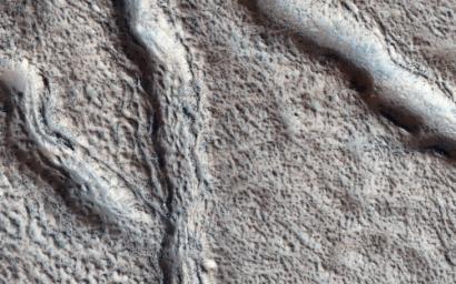 This observation from NASA's Mars Reconnaissance Orbiter shows the nature of large fissures in a smooth apron around a mound in the Phlegra region.