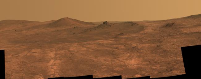 An elongated crater called 'Spirit of St. Louis,' with a rock spire in it, dominates a recent scene from the panoramic camera (Pancam) on NASA's Mars Exploration Rover Opportunity.