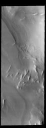 This image captured by NASA's 2001 Mars Odyssey spacecraft shows layering and linear ridges in Cavi Angusti. This region is near the south polar cap.