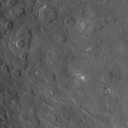 This image of Ceres, taken by NASA's Dawn spacecraft, features a large, steep-sided mountain and several intriguing bright spots. The mountain's height is estimated to be about 4 miles (6 kilometers). It is the highest point seen on Ceres so far.