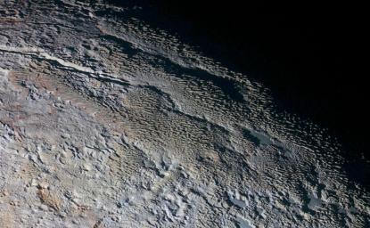 In this extended color image of Pluto taken by NASA's New Horizons spacecraft, rounded and bizarrely textured mountains, informally named the Tartarus Dorsa.