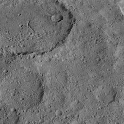 This view of Ezinu Crater on Ceres was taken by NASA's Dawn spacecraft on Oct. 19, 2015. Ezinu is the large crater in the top left corner of the image and contains a canyon-like feature near its center.