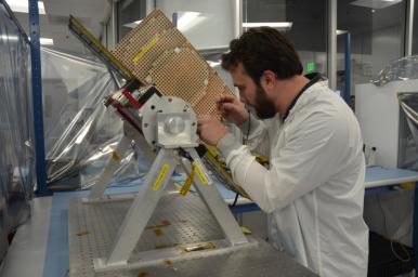 Engineers for NASA's MarCO (Mars Cube One) technology demonstration inspect one of the two MarCO CubeSats. Joel Steinkraus, MarCO lead mechanical engineer, left, and Andy Klesh, MarCO chief engineer, are on the team at NASA's Jet Propulsion Laboratory.