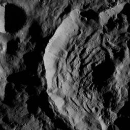 This view from NASA's Dawn spacecraft shows part of the crater named Sekhet on Ceres. Prominent shadows within the crater highlight Sekhet's central peak and mounds of material that have slumped downward from its walls.