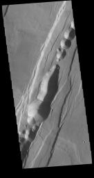This image captured by NASA's 2001 Mars Odyssey spacecraft shows part of Phlegethon Catena. The linear features are created by faulting.